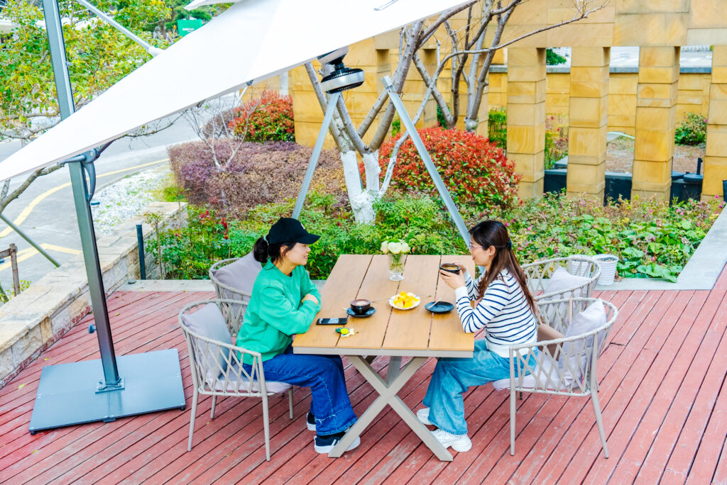 Guests seated beneath a Solargy smart solar umbrella on an outdoor patio