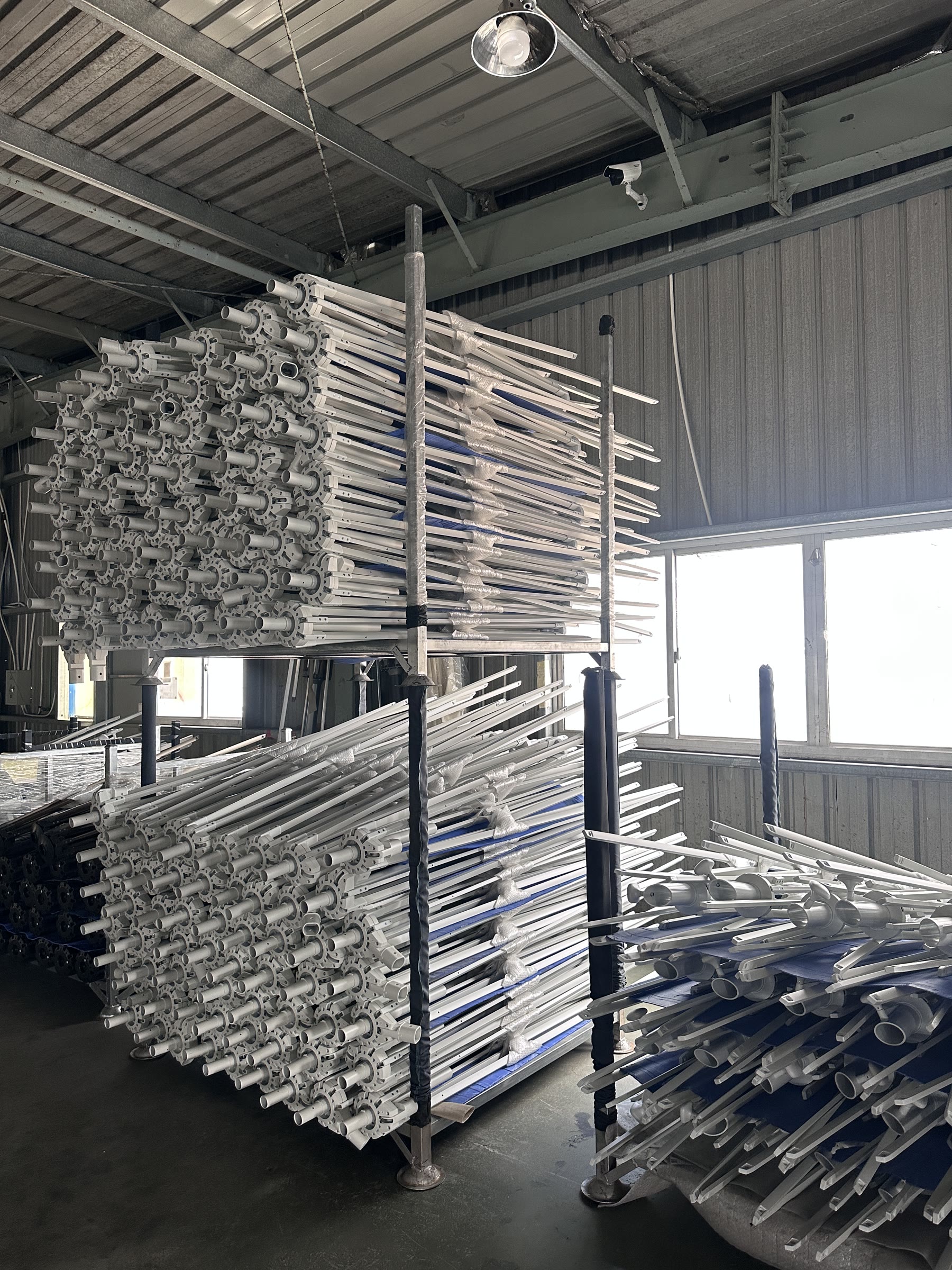 Completed umbrella frame assemblies on workshop racks