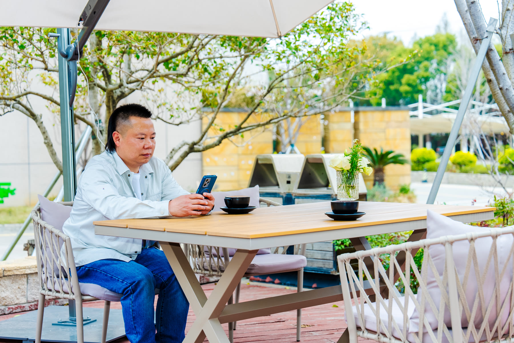 Un client profitant d'un café et de l'accès au téléphone sous un parasol solaire intelligent Solargy