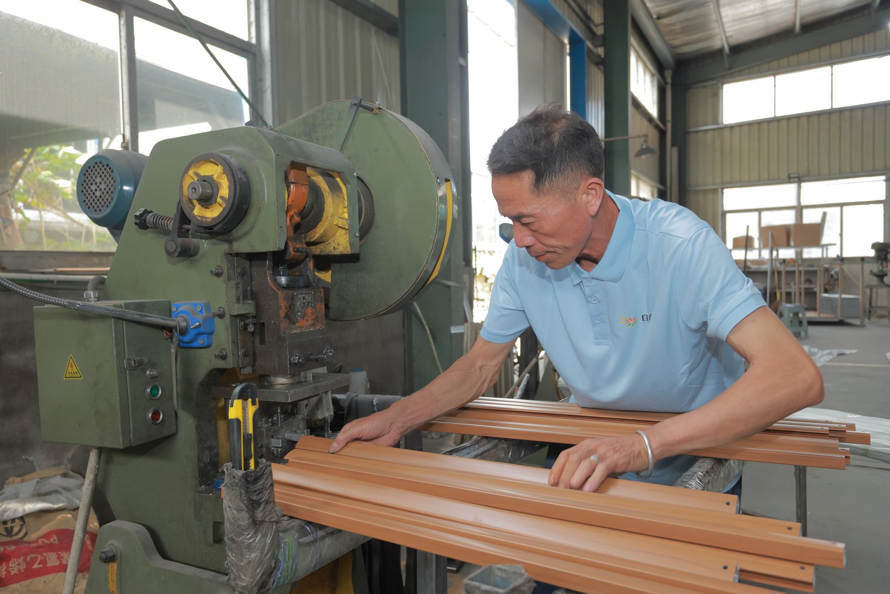 Solargy technician machining aluminum profiles for commercial solar umbrella frames