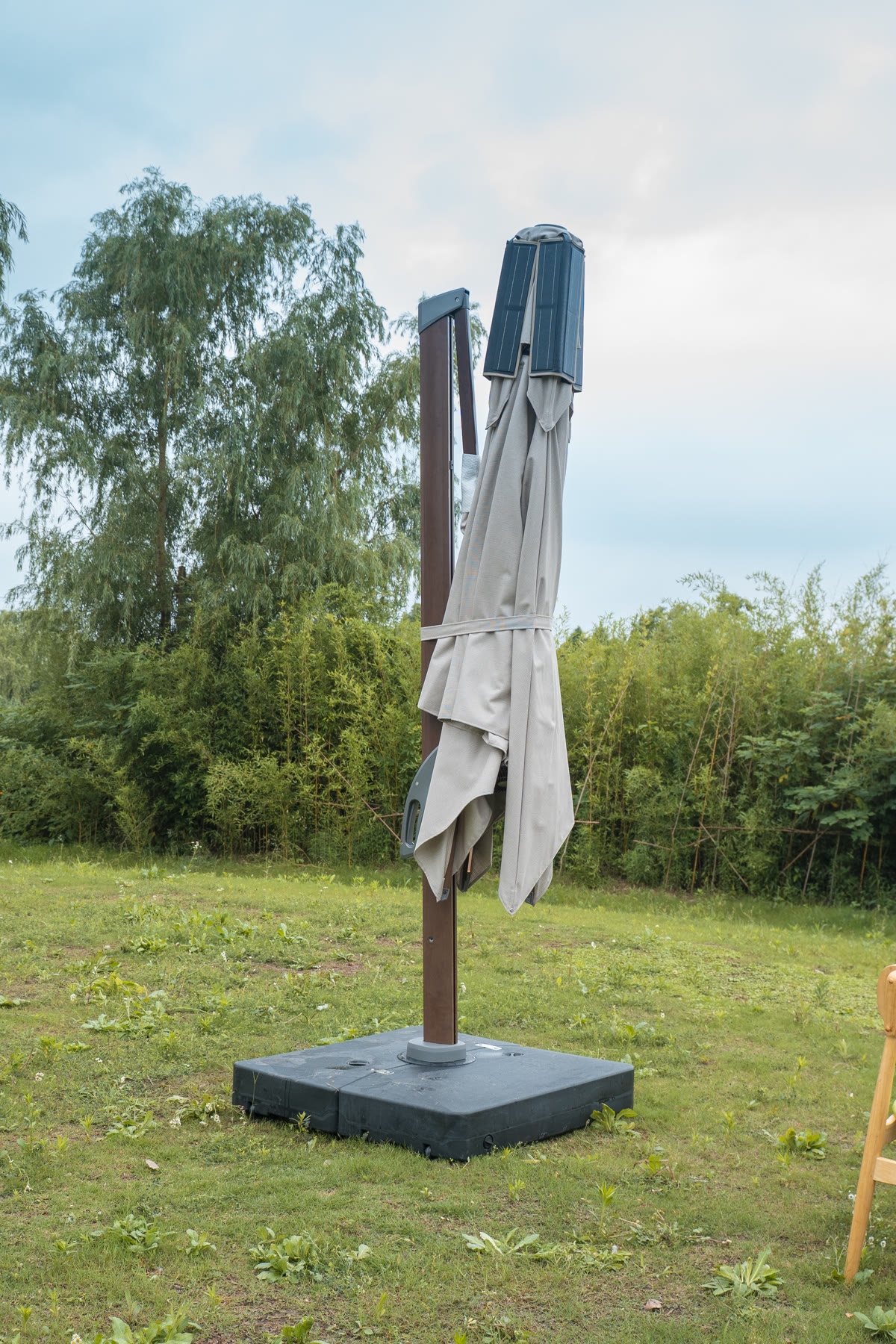 Solargy cantilever solar umbrella folded above its water-fillable base
