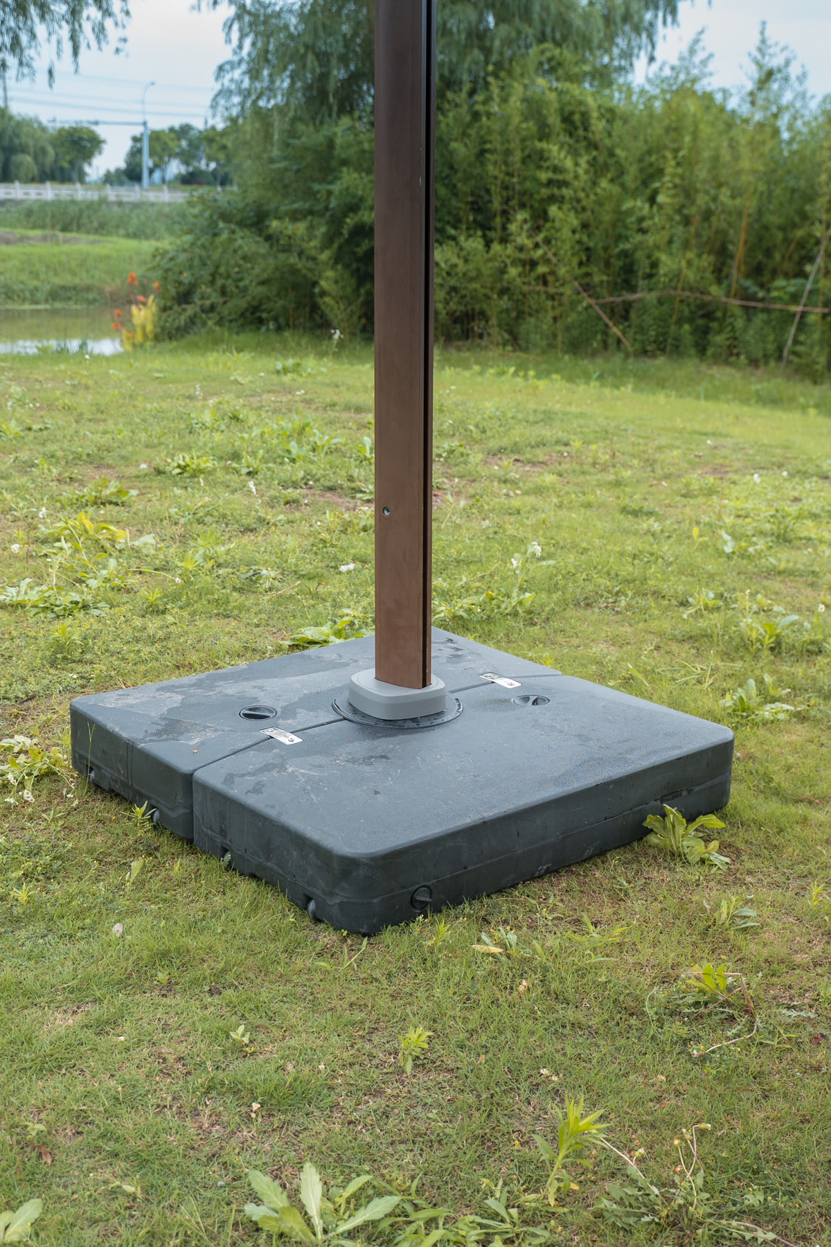 Water-filled ballast base installed beneath a Solargy cantilever umbrella mast